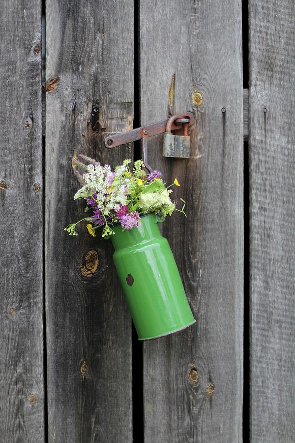 Flowers In Old Enamel Milk Churn On Wooden Door Photograph by Sylvia E.k Photography