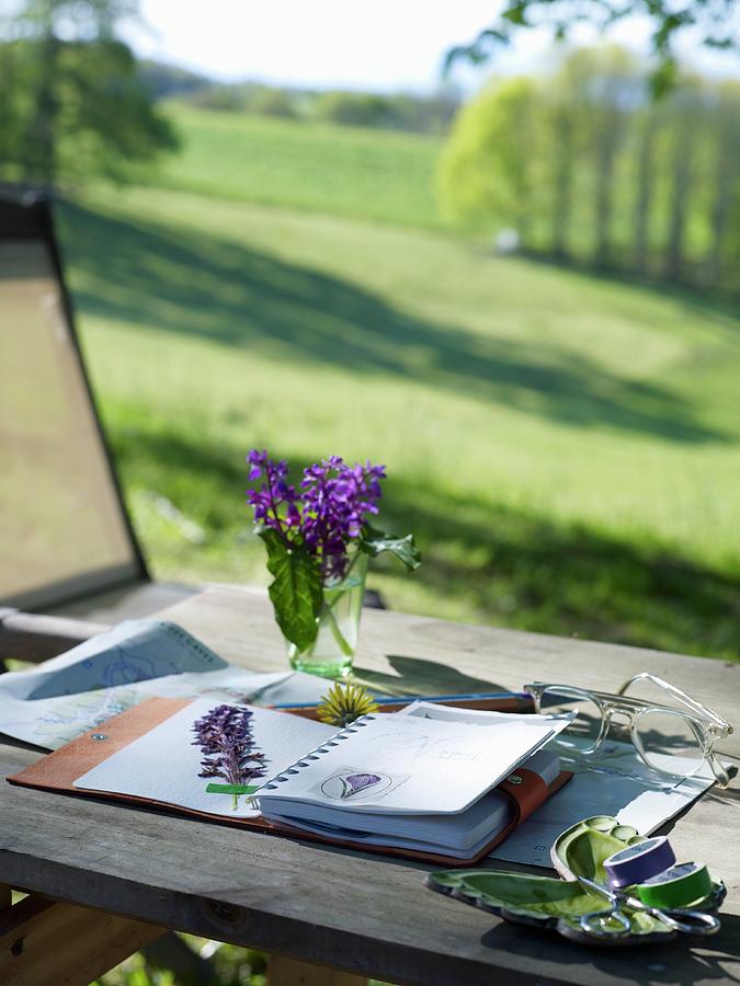 Flowers Pressed In Notebook On Table With View Across Landscape Photograph by Matteo Manduzio