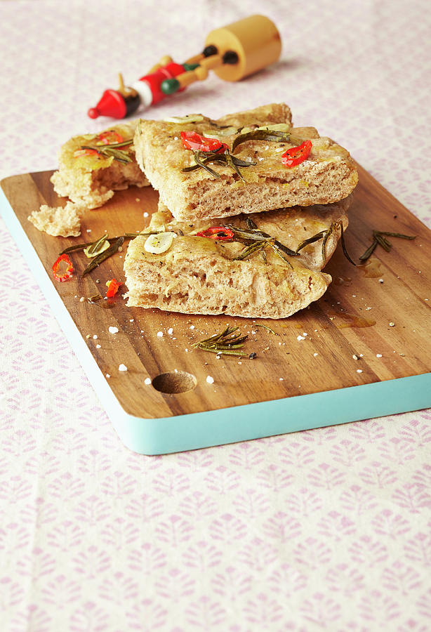 Focaccia With Chilli And Rosemary Sliced On A Wooden Board Photograph by Meike Bergmann