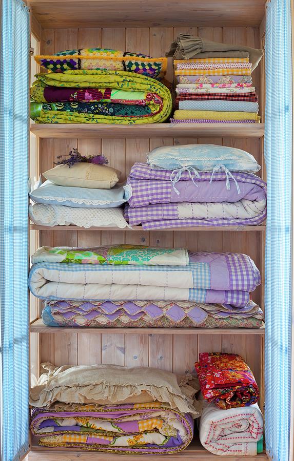 Folded Bedclothes In A Pastel Blue Laundry Cupboard Photograph by ...