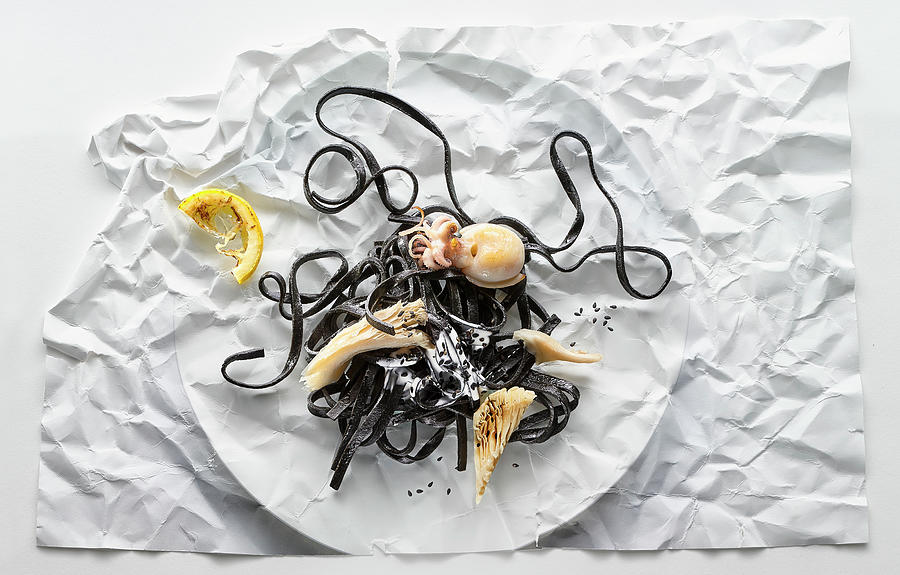 Food Art: Black Linguine With Octopus On Creased Paper Photograph by Manfred Rave
