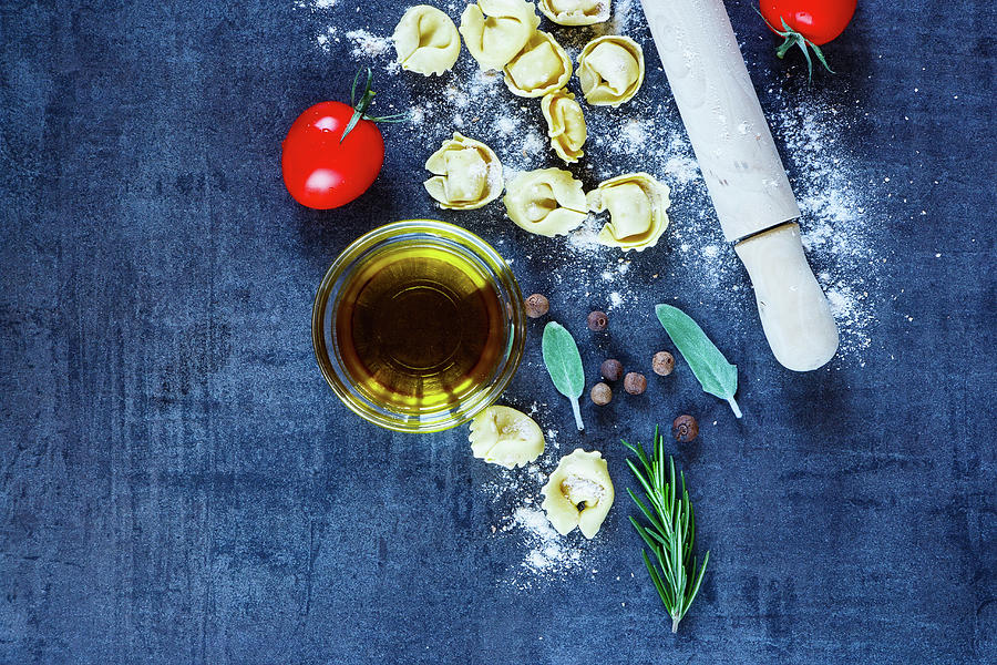 Food Background With Homemade Italian Pasta Tortellini, Tomatoes, Flour, Fresh Herbs And Olive Oil On Dark Vintage Texture Photograph by Yuliya Gontar