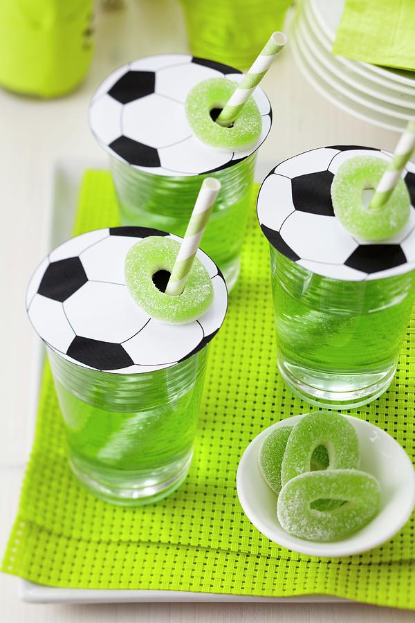 Football-shaped Paper Glass Covers With Straws And Jelly Sweets Photograph by Franziska Taube