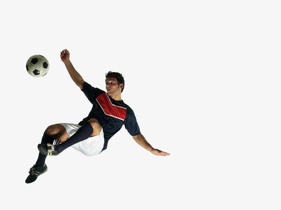 Footballer In Mid-air About To Kick Ball Photograph by John Lamb