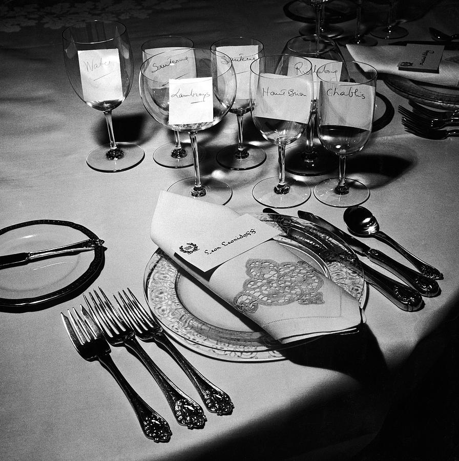 Wine Photograph - Forks, knives, spoons, wine glasses & invitations, part of the table settings for a gourmet dinner party. by Peter Stackpole