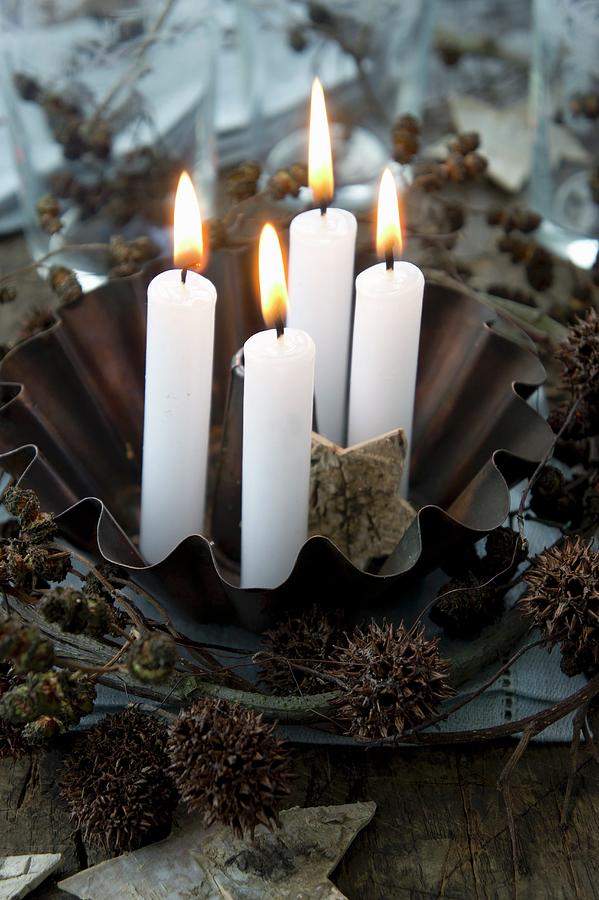 Four Candles In A Baking Tin With A Wreath Of Alderberries And Maple Fruit Photograph by Martina Schindler