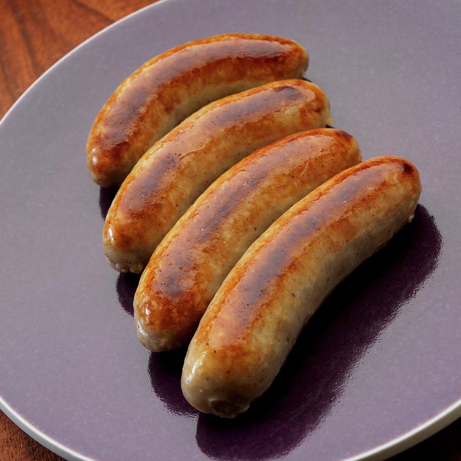 Four English Bangers On Plate Photograph by Paul Poplis