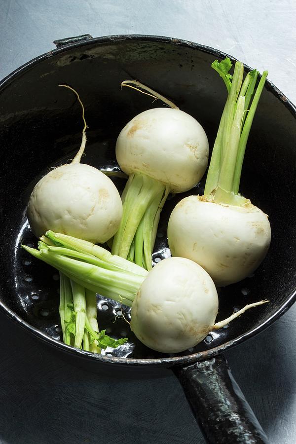 Four White Radishes In A Cast Iron Saucepan Photograph by Charlotte Von Elm