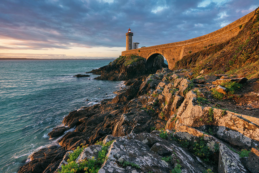 Lighthouse Digital Art - France, Brittany, Plouzane, Finistere, Lighthouse Phare Du Petit Minou With A Rocky Coast In The Warm Light At Sunrise by Niko Kersting
