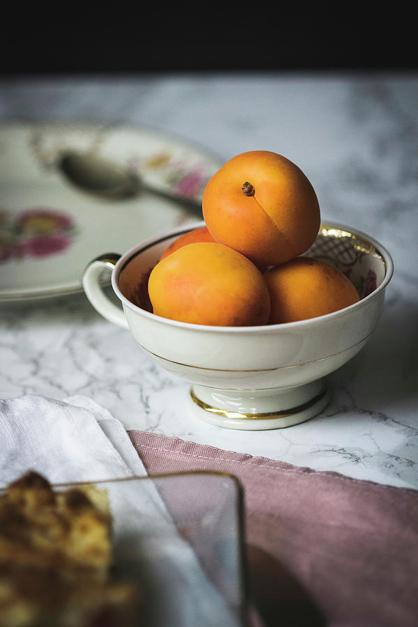 Fresh Apricots In A Porcelain Cup Photograph by Antonia Kurz