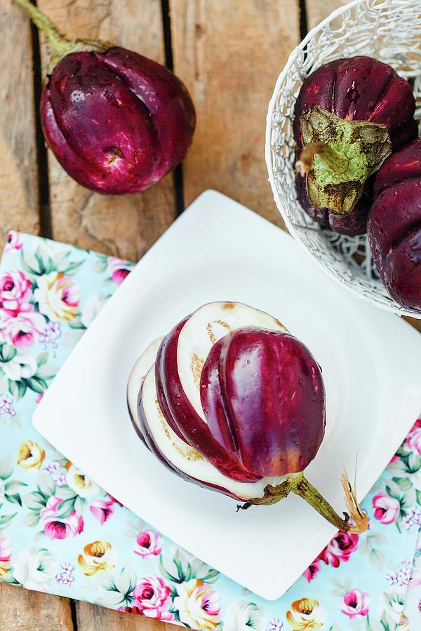Fresh Aubergines On A Wooden Table With Floral-patterned Napkins Photograph by Elizaveta Dogadaeva