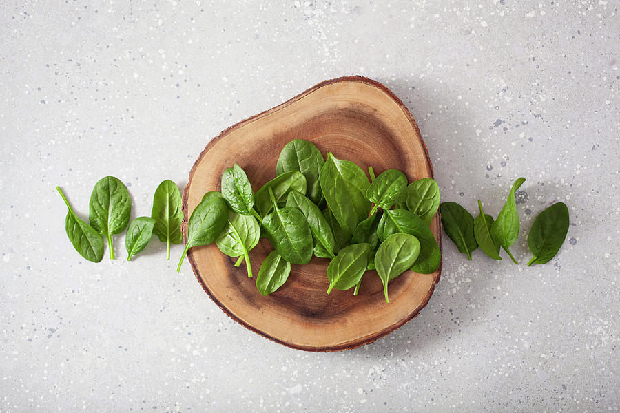 Fresh Baby Spinach On A Slice Of Log On A Grey Surface Photograph by Olga Miltsova