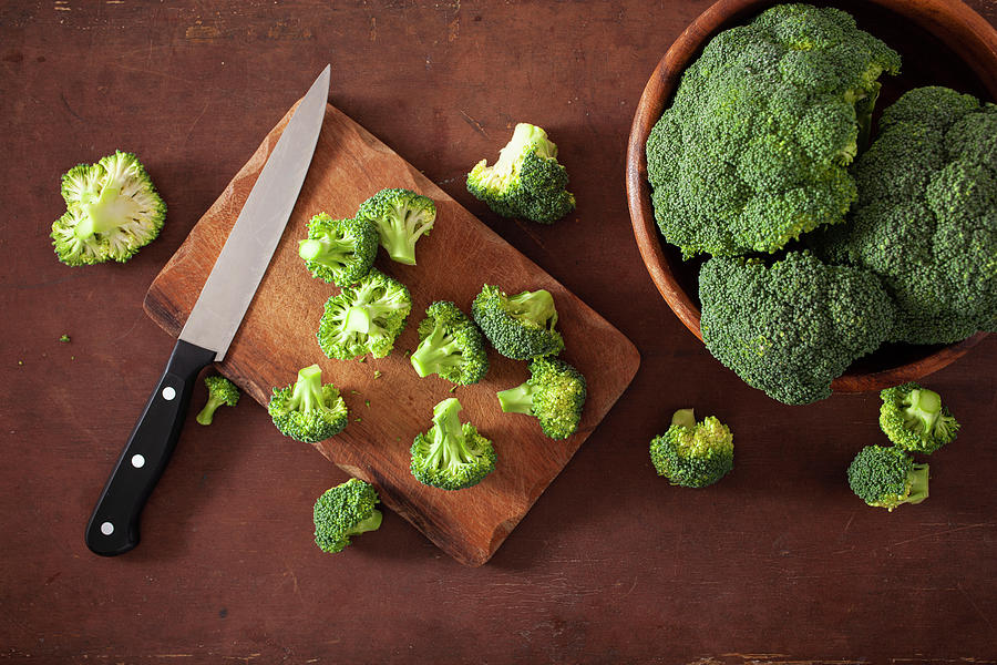 Fresh Broccoli With A Knife On A Wooden Chopping Board And In A Bowl Photograph by Olga Miltsova