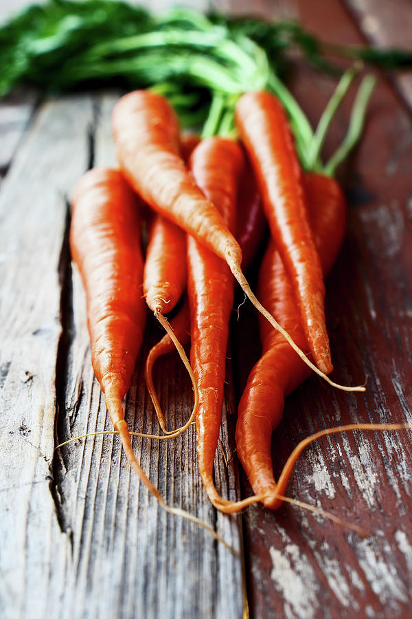 Fresh Carrots On A Rustic Wooden Surface Photograph by Yuliya Gontar