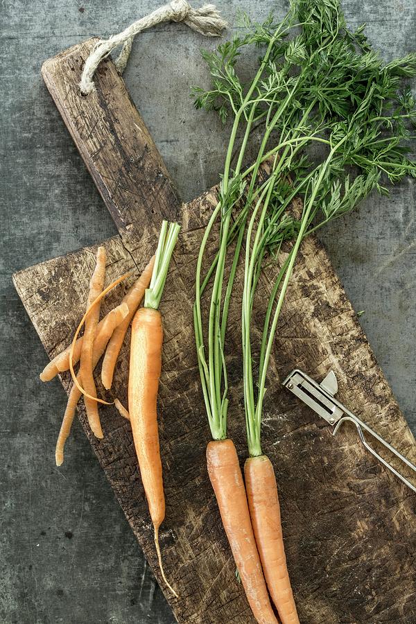 Fresh Carrots On A Wooden Board, Partially Peeled Photograph by Dees Kche