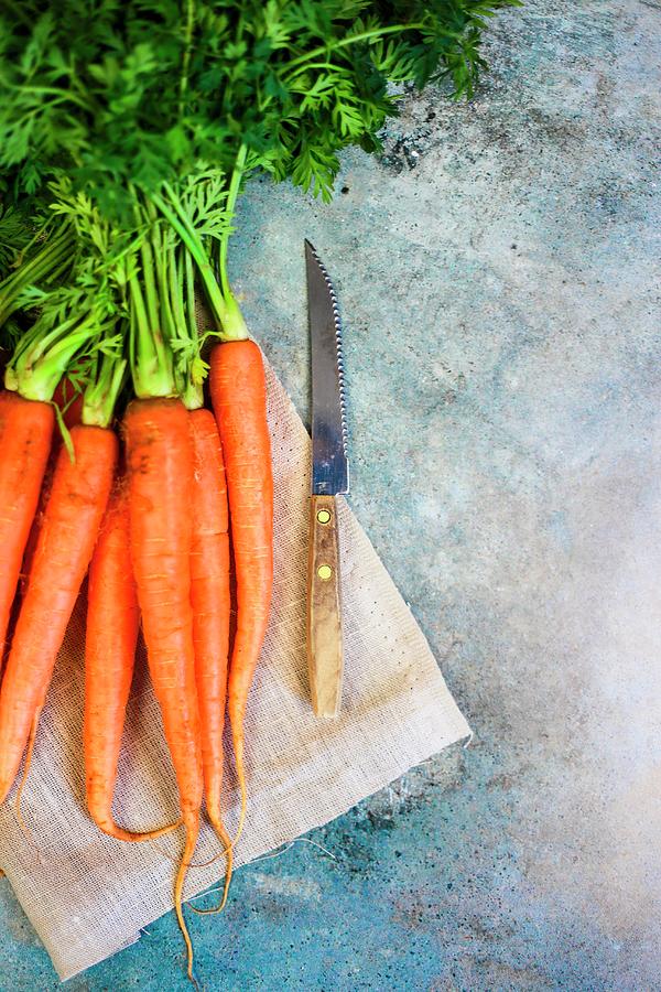 Fresh Carrots With A Knife Photograph by Claudia Gargioni