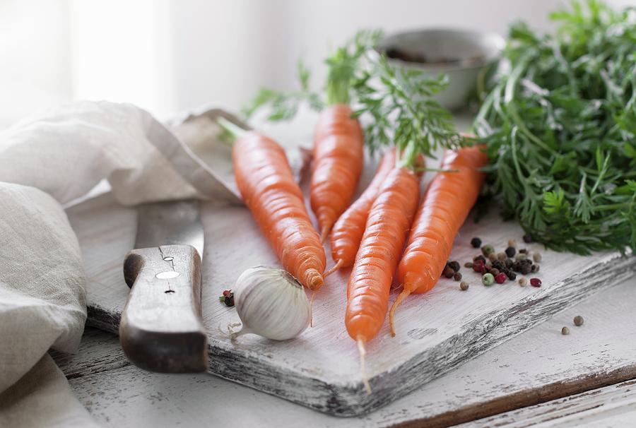 Fresh Carrots With Garlic And Pepper On A Chopping Board Photograph by Valeria Aksakova
