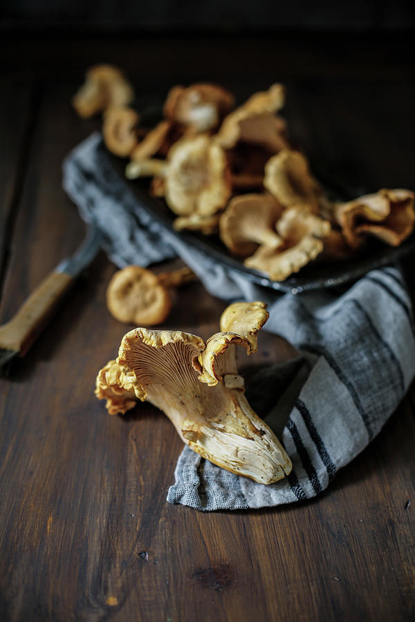 Fresh Chanterelle Mushrooms On A Cloth And On A Wooden Table Photograph by Rika Manabe Photography