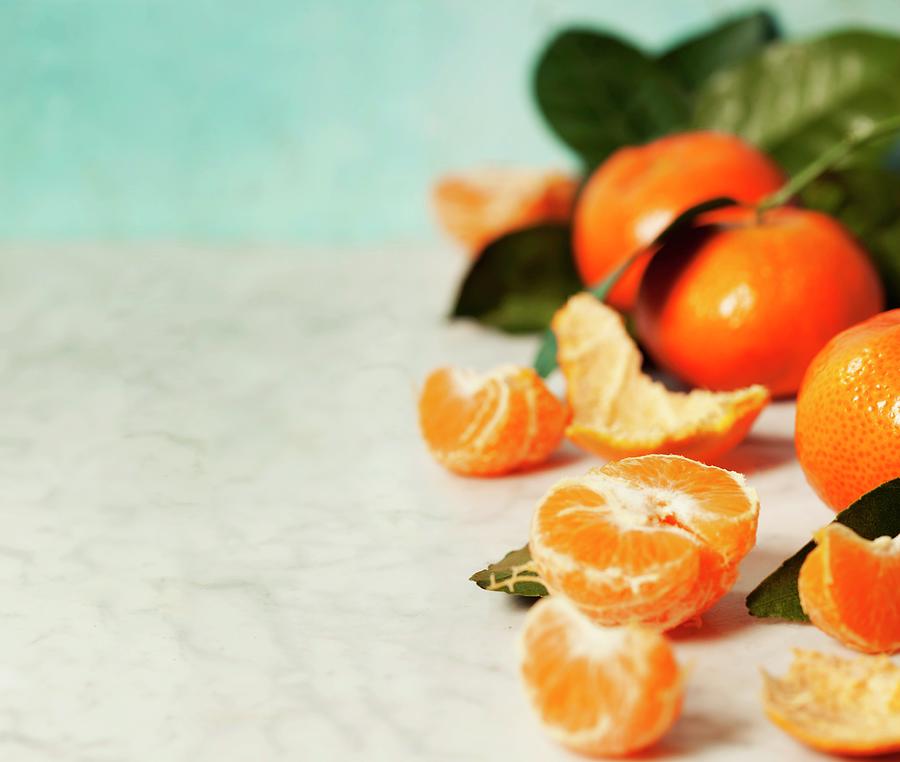 Fresh Clementines With Leaves On Blue Background Photograph by Natalia Klenova