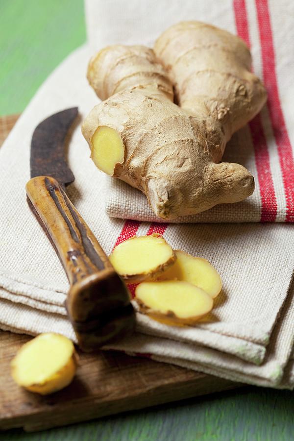 Fresh Ginger On A Tea Towel With A Knife Photograph by Hilde Mche