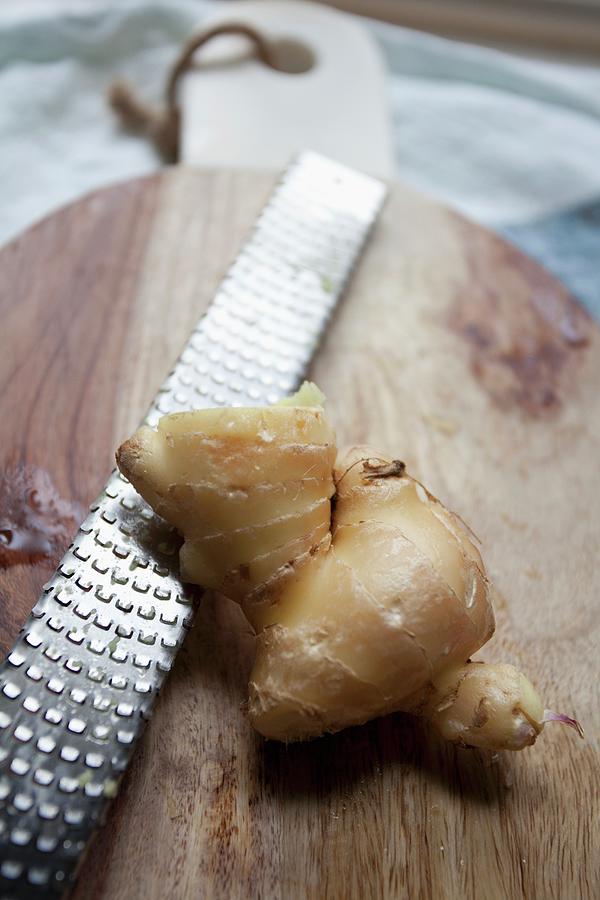 Fresh Ginger Root With A Grater On A Chopping Board Photograph by Ryla Campbell