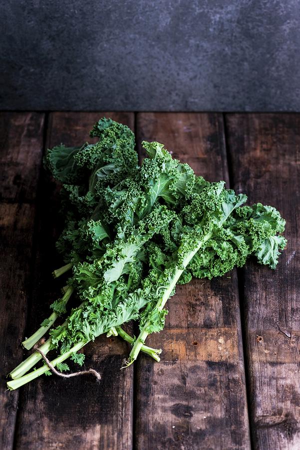 Fresh Kale On A Wooden Surface Photograph by Hein Van Tonder