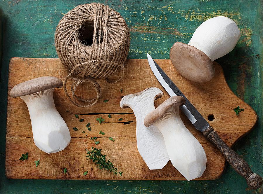 Fresh King Trumpet Mushroom On A Chopping Board With A Knife And Kitchen Twine Photograph by Ewgenija Schall