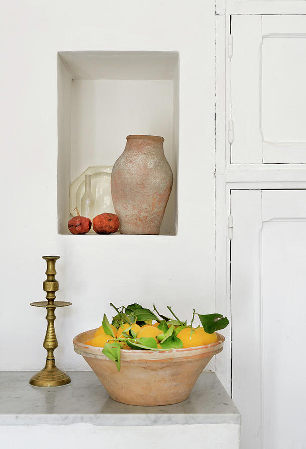 Fresh Lemons In Terracotta Bowl Below Terracotta Jug In Niche Photograph by Henri Del Olmo
