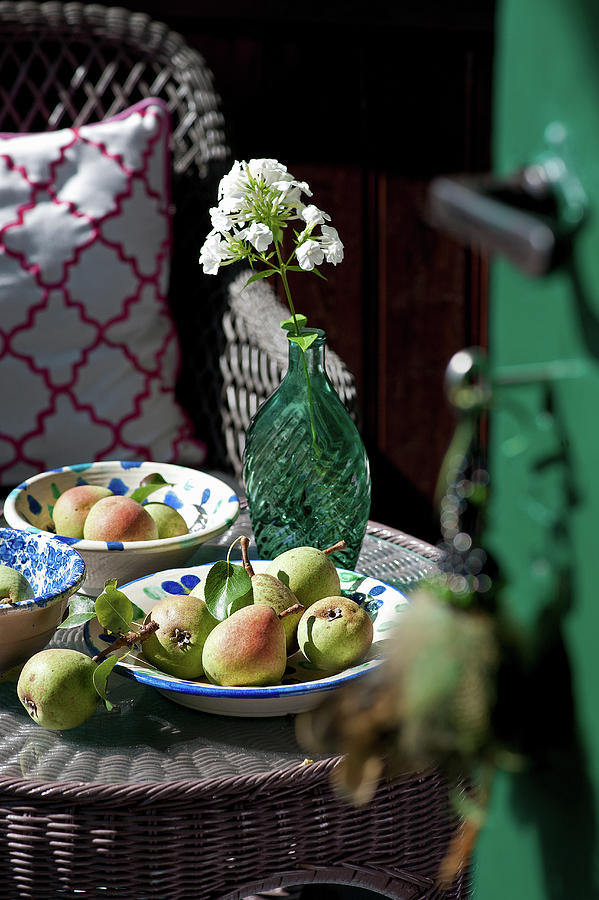Fresh Pears And Glass Vase Of Wildflowers On Wicker Table Photograph by Elisabeth Berkau
