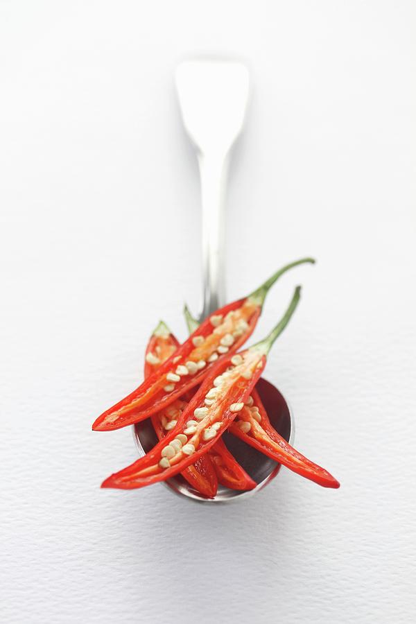 Fresh Sliced Red Chili Peppers On A Silver Spoon With A White Background And Space For Text Photograph by Ev Thomas