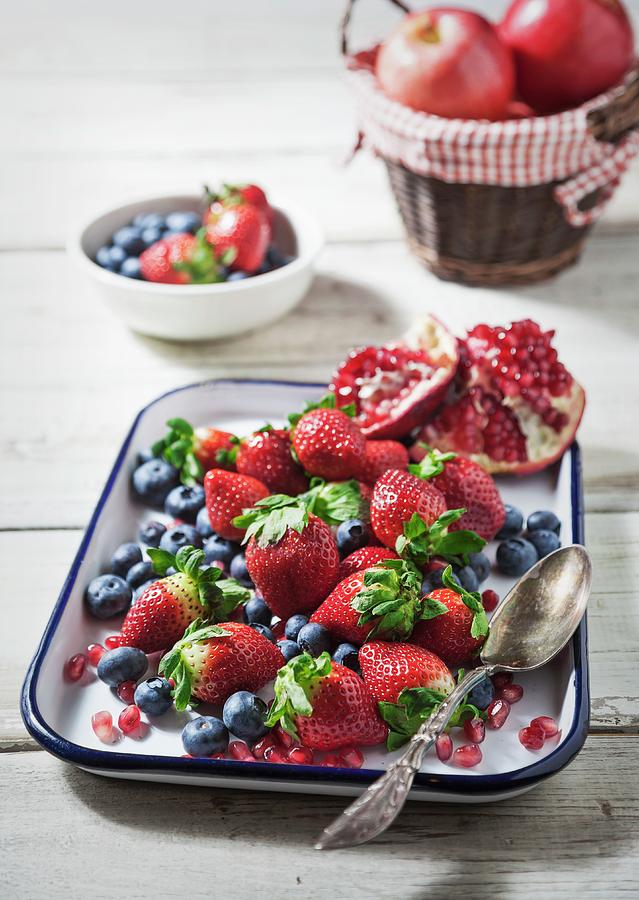 Fresh Strawberries, Blueberries And Pomegranate On An Enamel Baking Tray Photograph by George Crudo