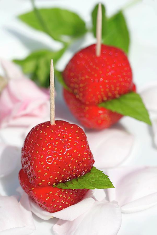 Fresh Strawberry Skewers With Mint Leaves On A Bed Of Rose Petals Photograph by Johanna Von Aesch