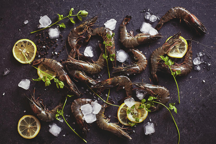 Fresh Tiger Prawn And Lemon Slices Placed On A Dark Tabletop Photograph by Tan Yong Khin