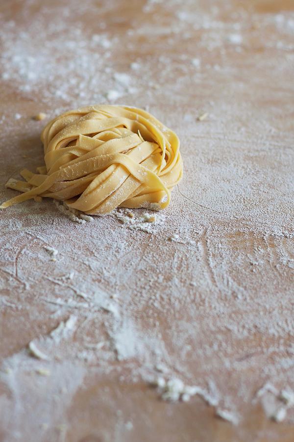 Fresh, Uncooked Pasta On A Floured Wooden Board Photograph by Malgorzata Laniak