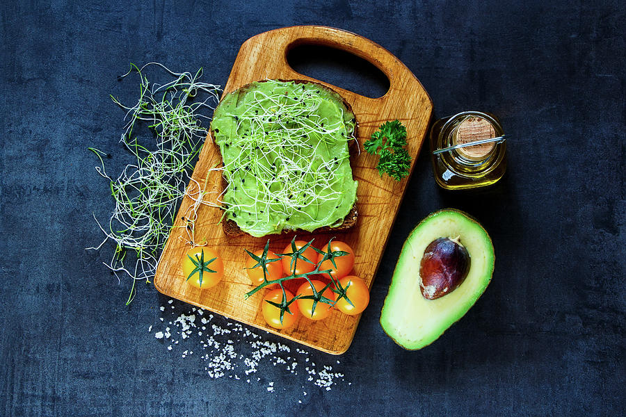 Fresh Vegetarian Sandwich With Whole Grain Bread, Alfalfa And Guacamole On Rustic Wooden Cutting Board Over Dark Vintage Background Photograph by Yuliya Gontar