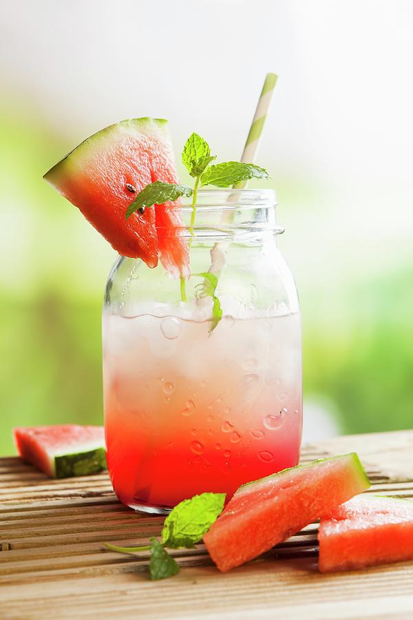 Fresh Watermelon Juice In A Glass Jar With Ice On An Outside Picnic Table Photograph by Stacy Grant