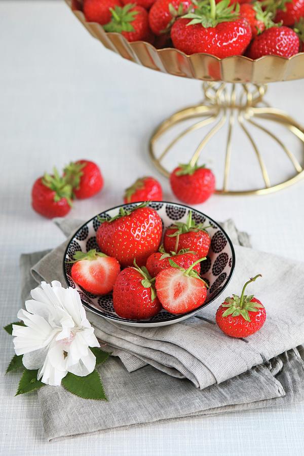 Fresh Whole And Halved Strawberries In A Bowl, Decorated With A Paper Flower Photograph by Regina Hippel