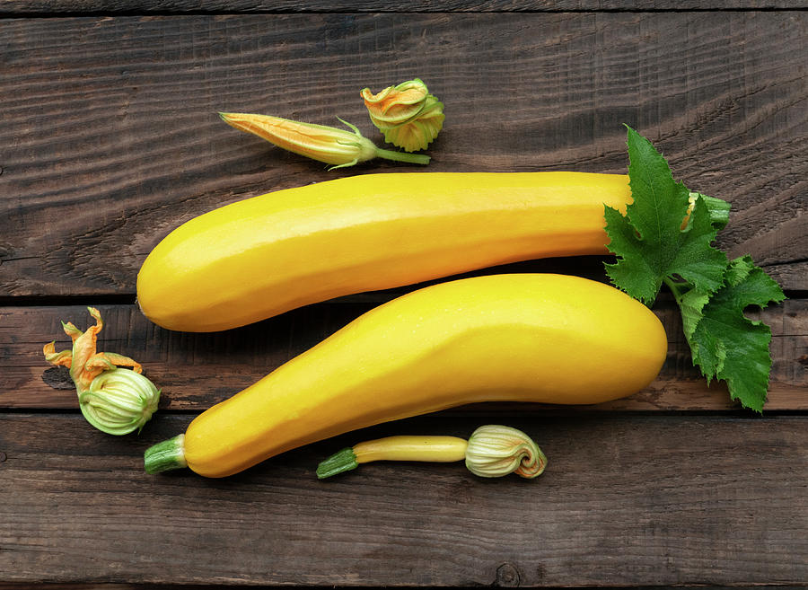 Fresh Yellow Zucchini And Zucchini Flowers On A Wooden Background Photograph by Magdalena & Krzysztof Duklas