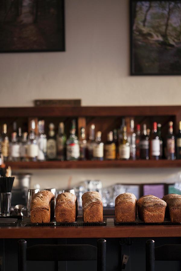 Freshly Baked Loaves Of Bread Cooling On A Bar Photograph by Jennifer Martine