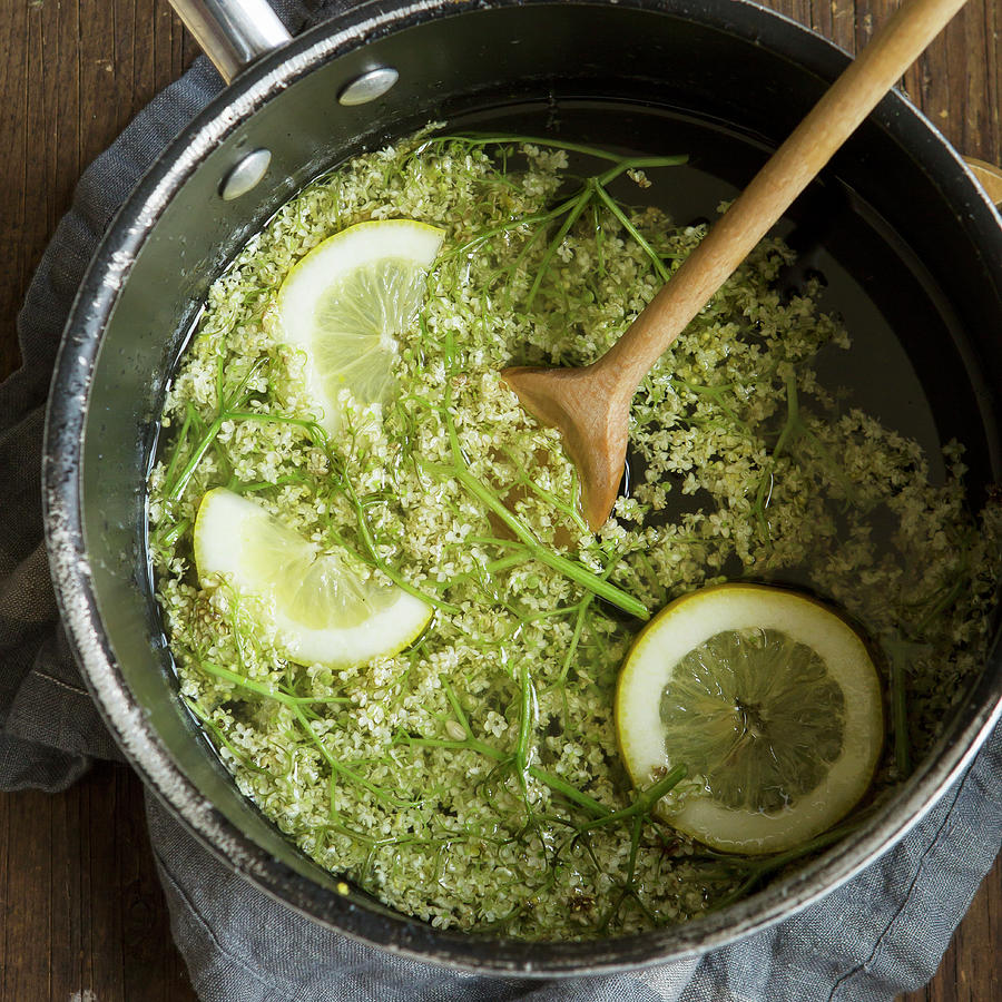 Freshly Picked Elderflowers In A Large Saucepan With Lemons And A Wooden Spoon Photograph by Stacy Grant