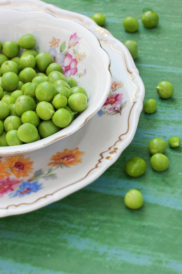 Freshly Podded Organic Peas In Old Crockery And On The Tabletop Photograph by Sabine Lscher