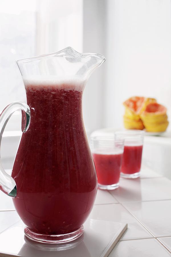 Freshly Pressed Grapefruit And Pomegranate Juice In A Glass Jug Photograph by Katharine Pollak