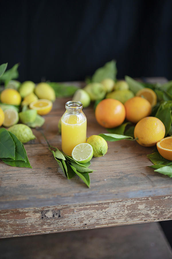 Freshly Pressed Orange Juice And Fresh Citrus Fruits On A Rustic Wooden Table Photograph by Anna-lena Rpfl
