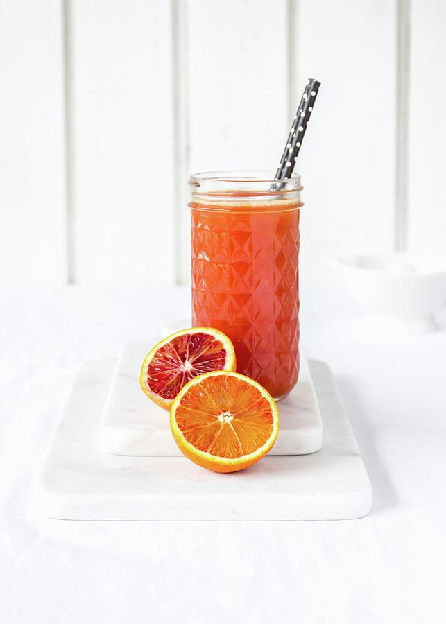 Freshly Squeezed Blood Orange Juice In A Glass With A Drinking Straw Photograph by Emma Friedrichs