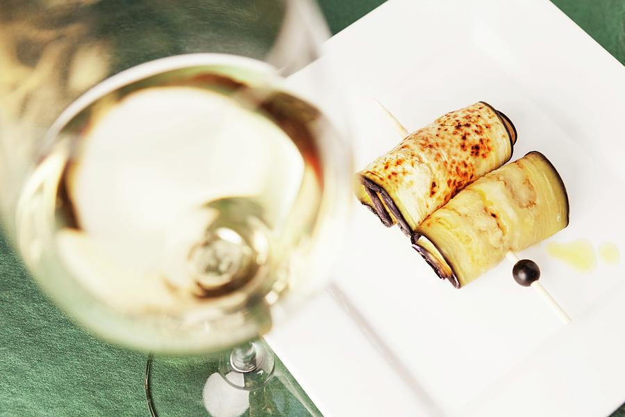 Fried Aubergine Rolls And A Glass Of White Wine Photograph by Anneliese Kompatscher