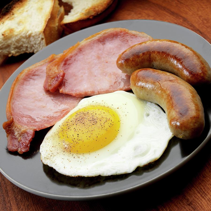 Fried Egg With Two Bangers And Two English Bacon Photograph by Paul Poplis