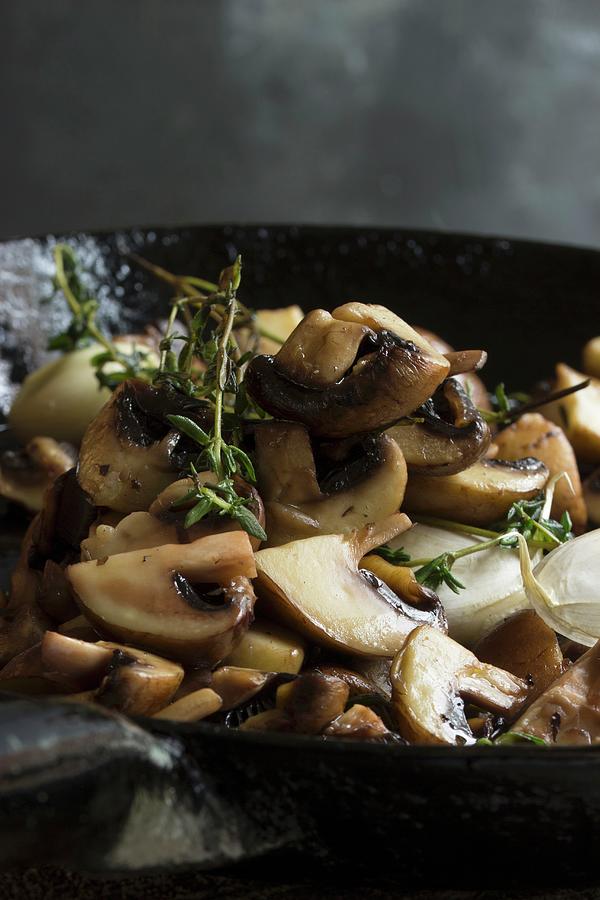 Fried Mushrooms With Thyme In A Cast Iron Pan Photograph by Charlotte Von Elm