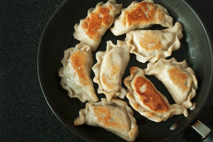 Fried Pierogi polish Meat Dumplings In A Frying Pan Photograph by Edyta Girgiel