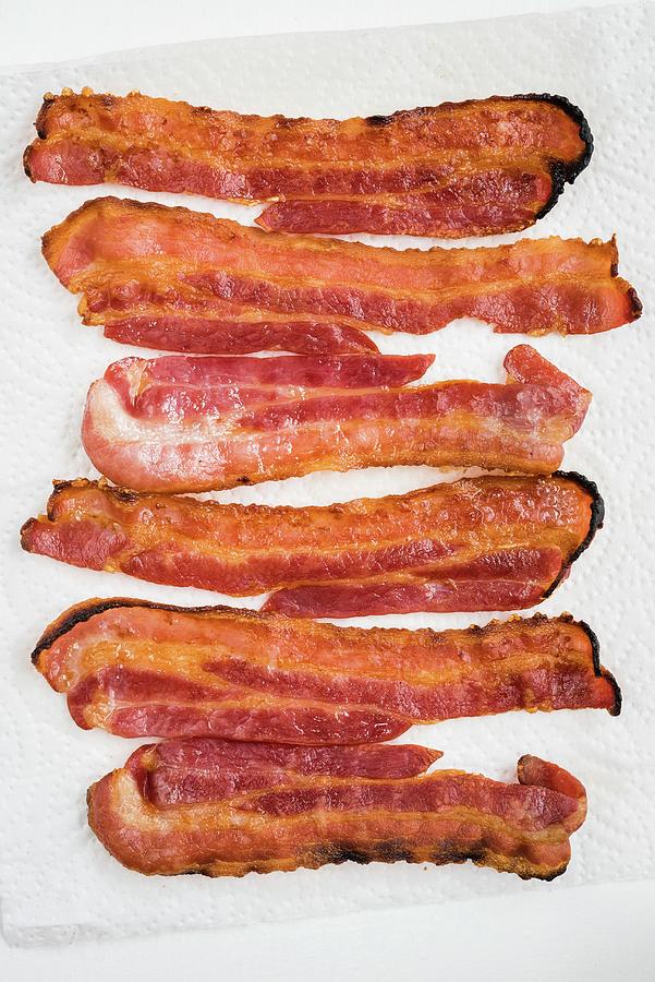 Fried Slices Of Bacon On Kitchen Roll seen From Above Photograph by Lucy Parissi