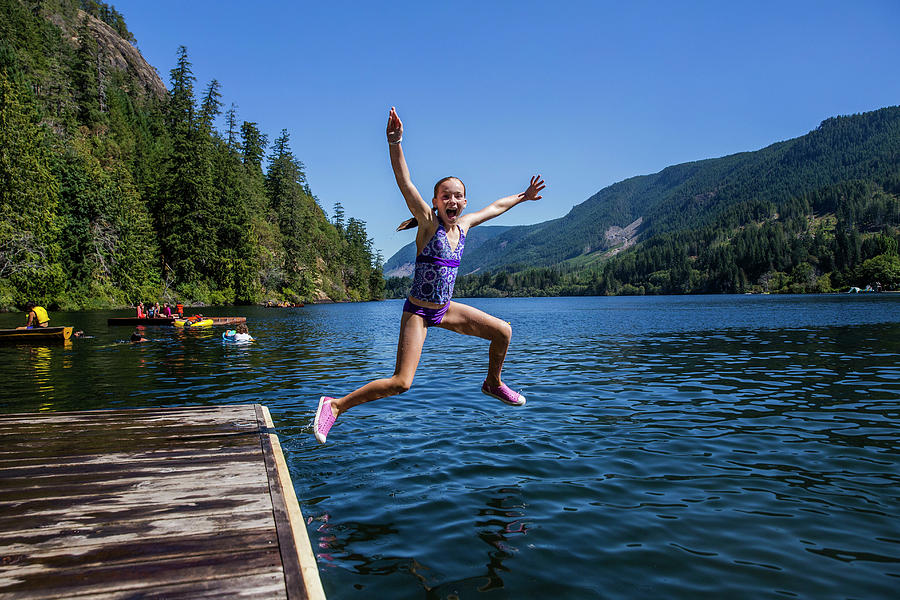 Front View Of Girl Jumping Into The Lake Surrounded By Moutains ...